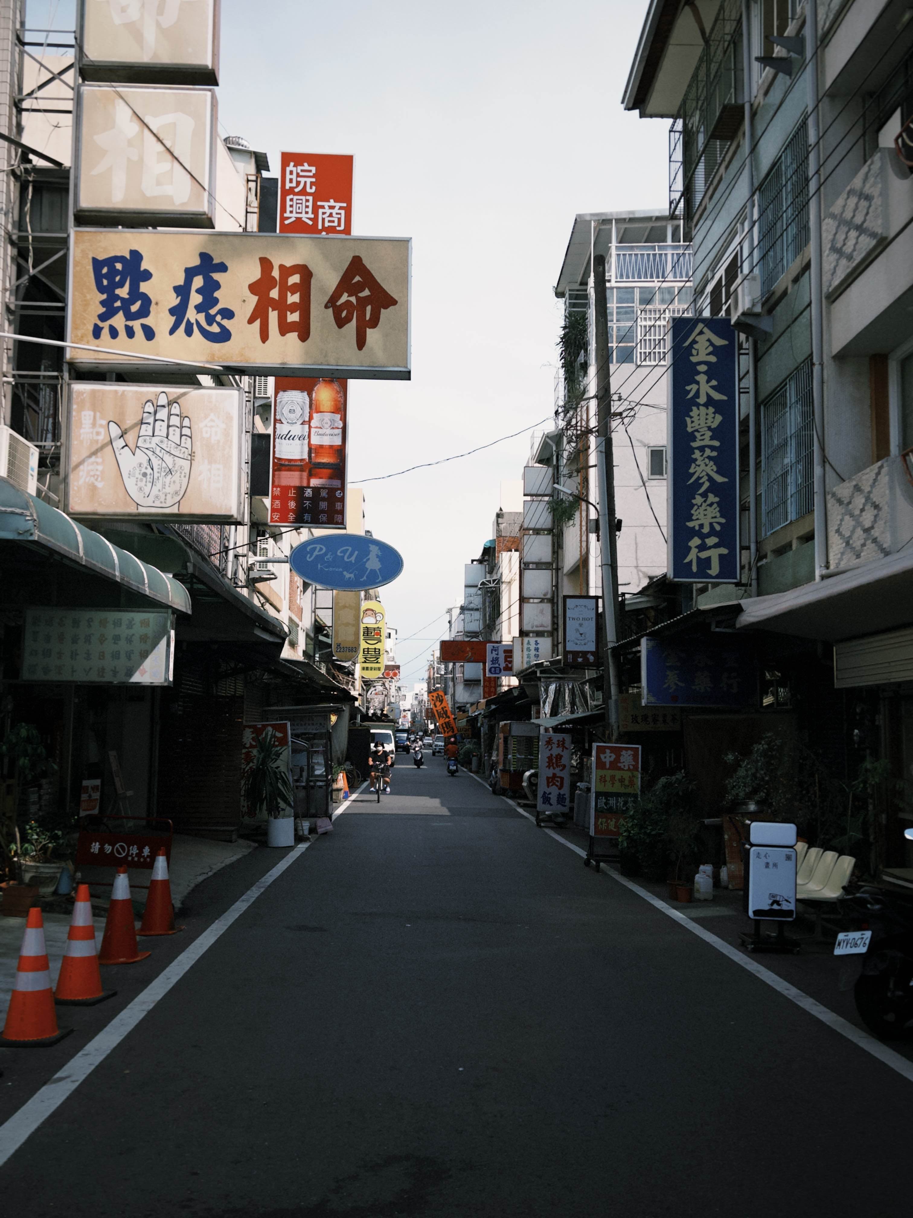 Traditional street in Taiwan with various shop signs and a narrow road.