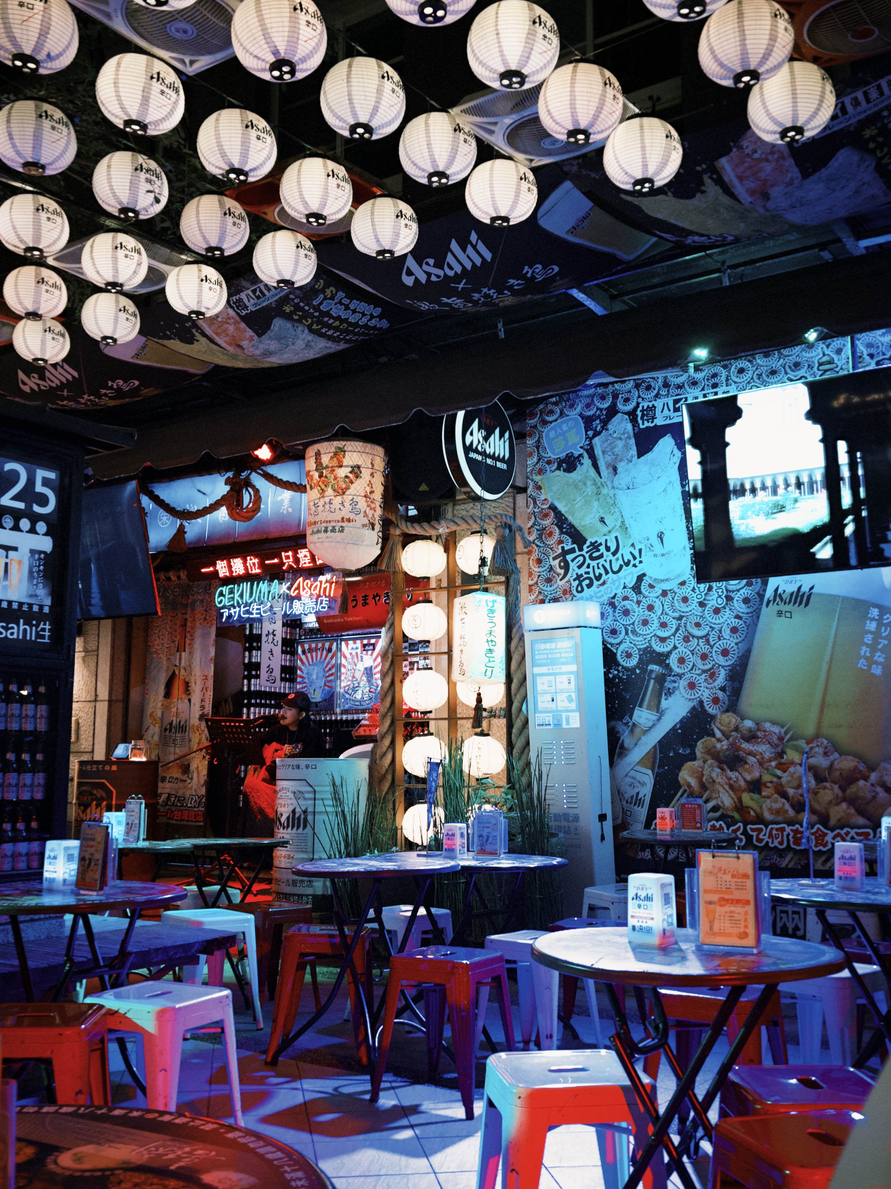 Japanese-themed izakaya with lanterns and vibrant lighting.